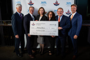 Group of people holding donation check from Congressional Sports for Charity