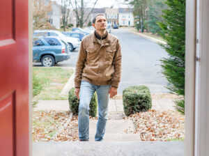 Man walking into door of a home
