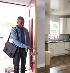 Man Coming Home From Work And Opening Door Of Apartment