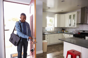 Man Coming Home From Work And Opening Door Of Apartment